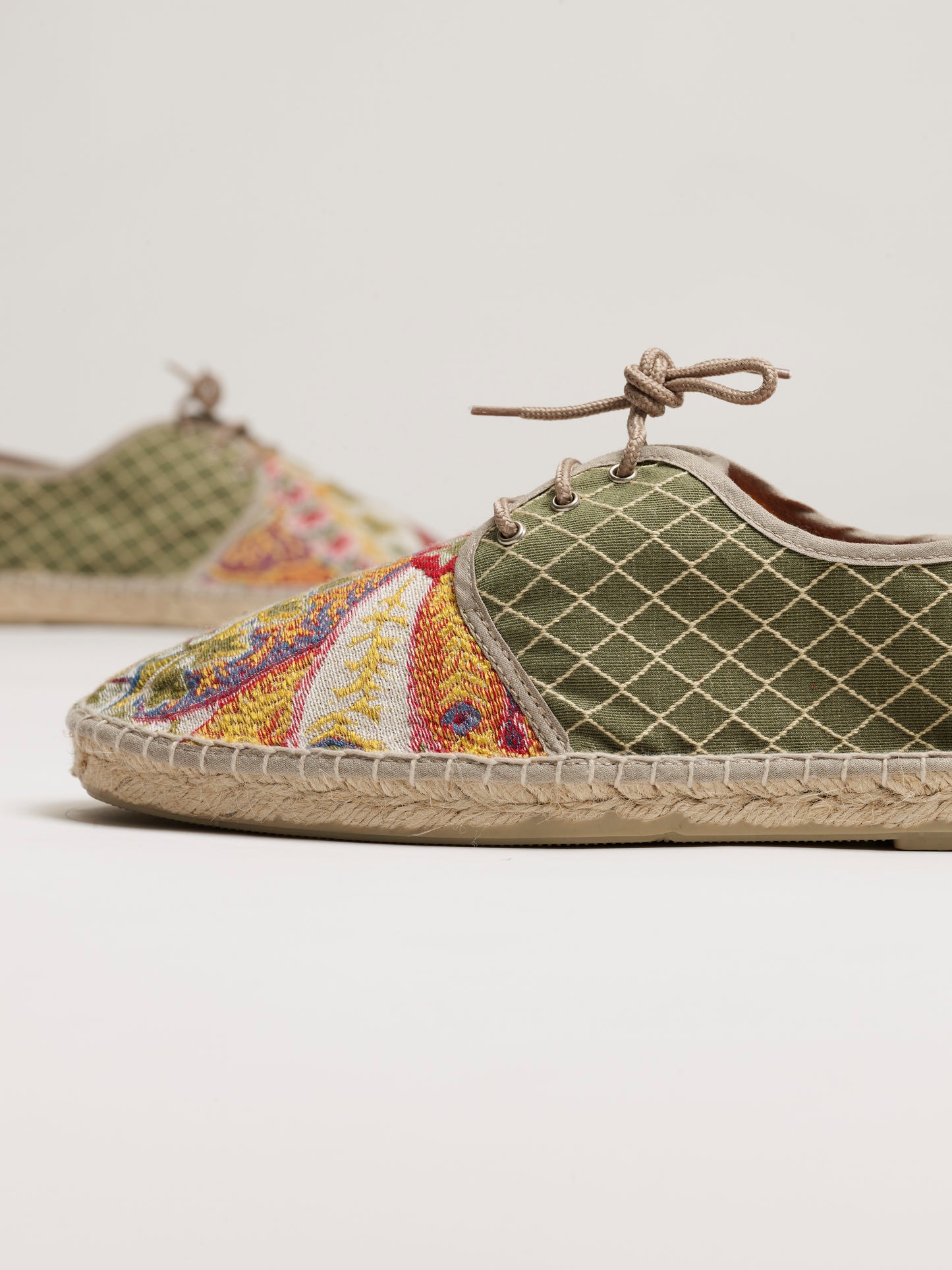 Alpargata para hombre plana, cierre con cordones, parte delantera en tejido estampado cachemir y parte trasera verde bordada a rombos. Original y artesanal