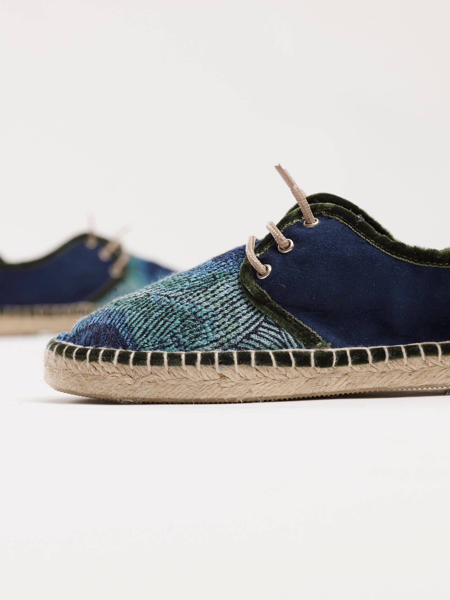 Alpargata para mujer plana, cierre con cordones, parte delantera en tejido estampado Pavo Real y parte trasera azul marino. Ribete en terciopelo verde Original y artesanal