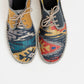 Alpargata para hombre plana, cierre con cordones, parte delantera en tejido estampado étnico y parte trasera gris petróleo y mostaza. Original y artesanal