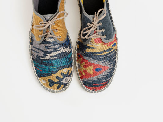 Alpargata para hombre plana, cierre con cordones, parte delantera en tejido estampado étnico y parte trasera gris petróleo y mostaza. Original y artesanal