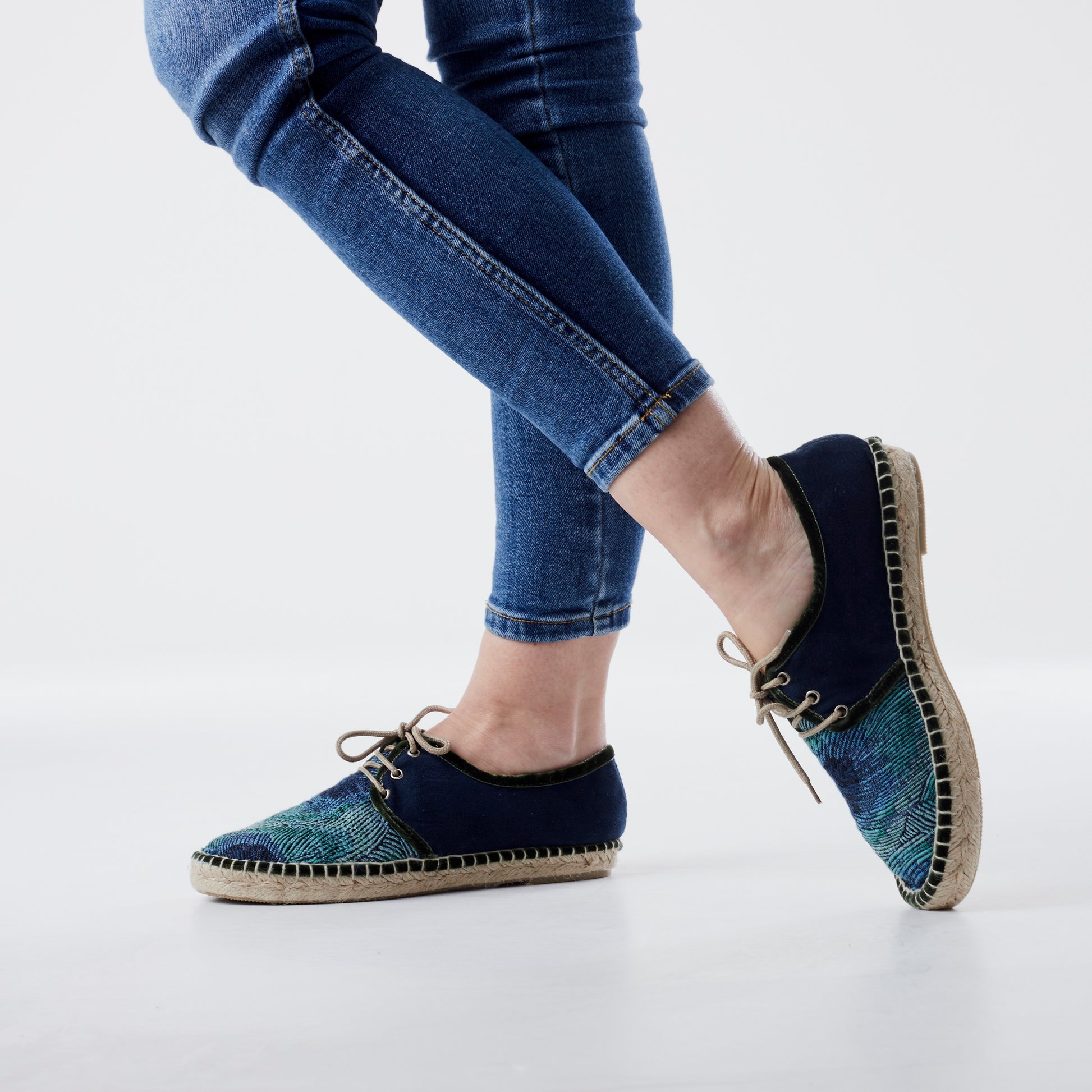 Alpargata para mujer plana, cierre con cordones, parte delantera en tejido estampado Pavo Real y parte trasera azul marino. Ribete en terciopelo verde Original y artesanal