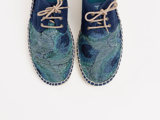 Alpargata para mujer plana, cierre con cordones, parte delantera en tejido estampado Pavo Real y parte trasera azul marino. Ribete en terciopelo verde Original y artesanal